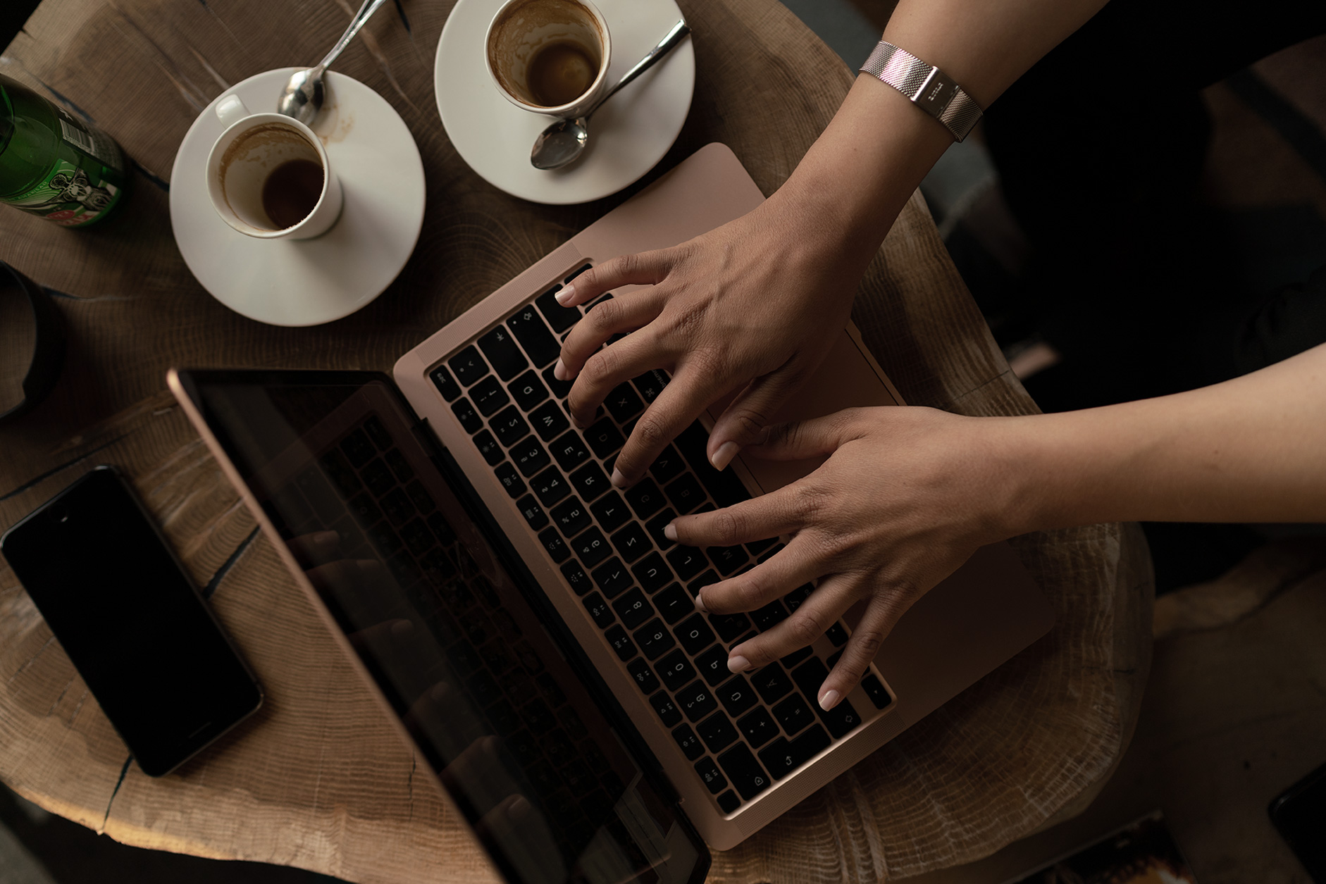 the-woman-s-hands-on-the-laptop-and-coffee-cups-ne